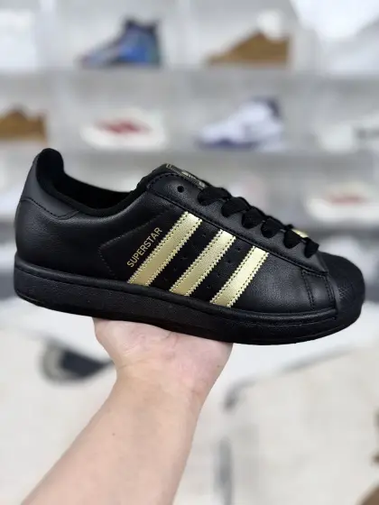 ▪️WZ纯原 adidas originals Superstar 2 潮流运动薄底 耐磨透气 低帮 板鞋 男女同款 黑金 ▪️ (352⁄3 36 362⁄3 371⁄3 38 382⁄3 391⁄3 40 402⁄3 411⁄3 42 422⁄3 431⁄3 44 442⁄3 451⁄3) ▪️货号:KJ3550 ▪️Superstar系列以贝壳头设计著称,这一标志性元素使其在众多鞋款中脱颖而出.贝壳头不仅具有防撞和保护脚尖的作用,还成为了时尚界的经典符号.作为阿迪达斯经典系列的一部分,Superstar鞋侧常常饰有三叶草标志,彰显品牌身份与品质保证.鞋面采用优质皮革,质感高级且耐磨耐穿.柔软橡胶底则提供了良好的缓震效果和抓地力.Superstar板鞋以其舒适的穿着体验而著称.柔软橡胶底和合理的内部空间设计,使得长时间穿着也不会感到疲劳.简约复古的鞋型搭配贝壳头设计,使得Superstar成为一款百搭鞋款.无论是搭配牛仔裤、休闲裤还是裙子,都能轻松驾驭各种风格.采用优质材质和精湛工艺打造,Superstar板鞋具有出色的耐用性和耐磨性,能够陪伴消费者度过漫长的时光.自诞生以来,Superstar逐渐成为街头潮流文化的代表之一.众多潮人、明星和设计师都钟爱这款鞋款,纷纷将其纳入自己的穿搭中.